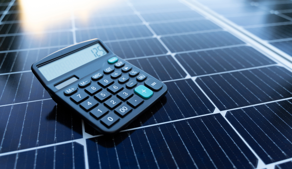 Calculator placed on solar panel calculating solar energy savings and installation cost