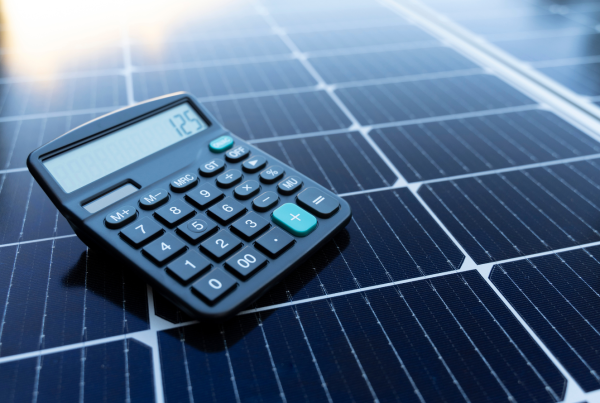 Calculator placed on solar panel calculating solar energy savings and installation cost