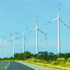Wind turbines along a highway generating clean renewable energy in a rural landscape