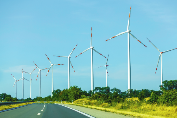 Wind turbines along a highway generating clean renewable energy in a rural landscape
